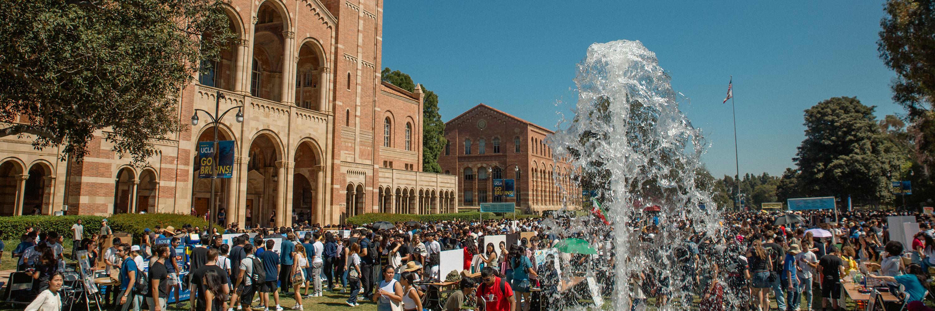 Hundreds of students explore booths on a sunny day at UCLA's Enormous Activities Fair, where they learn about campus organizations and departments.